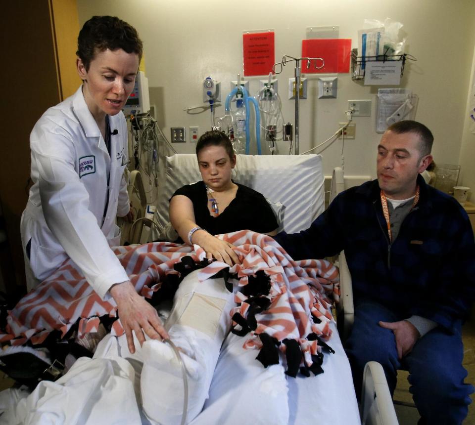 Dr. Daphne Beingessner, left, talks the media about Washington mudslide survivor Amanda Skorjanc's injuries at Harborview Medical Center, with Ty Suddarth at right, Wednesday, April 9, 2014, in Seattle. On March 22, Skorjanic said she was trapped in a pocket formed by her broken couch and pieces of her roof with her infant son. Skorjanic said that she remembers hearing the voices of several men coming to her aid, she had two broken legs and a broken arm. (AP Photo/The Herald, Dan Bates, Pool)
