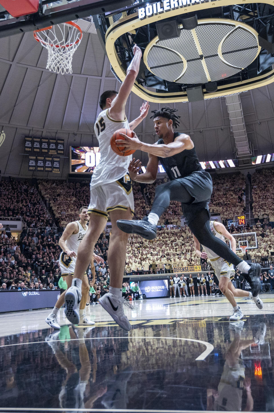 Michigan State guard A.J. Hoggard (11) passes the ball off while being defended by Purdue center Zach Edey (15) during the first half of an NCAA college basketball game Saturday, March 2, 2024, in West Lafayette, Ind. (AP Photo/Doug McSchooler)