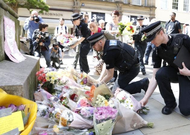 Police officers lay flowers in tribute to the Manchester victims: Martin Rickett/PA