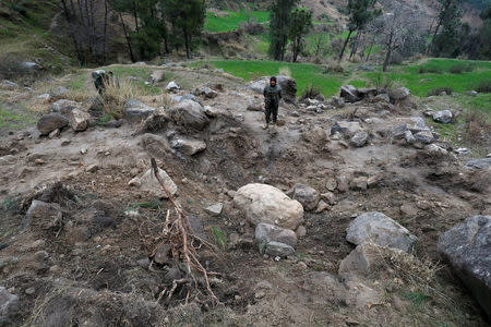 Pakistan's army soldier stands at the edge of a crater, after Indian military aircrafts struck on February 26, according to Pakistani officials, in Jaba village, near Balakot, Pakistan, March 7, 2019. REUTERS/Akhtar Soomro