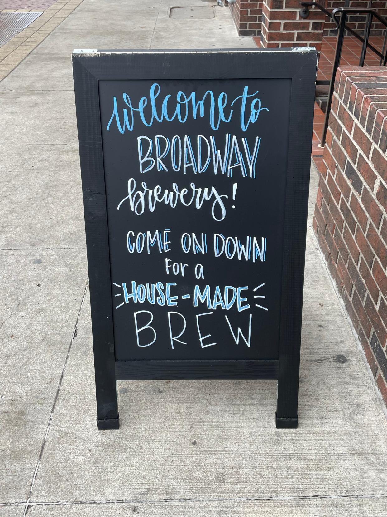 A chalkboard sign beckons patrons down a set of stairs to Broadway Brewery on Tuesday, March 26, 2024.