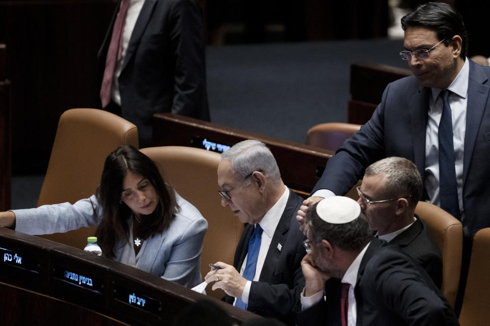 Israel's Prime Minister Benjamin Netanyahu, center, confers with lawmakers at a session of the Knesset, Israel's parliament, in Jerusalem, Monday, July 24, 2023. (AP Photo/Maya Alleruzzo)
