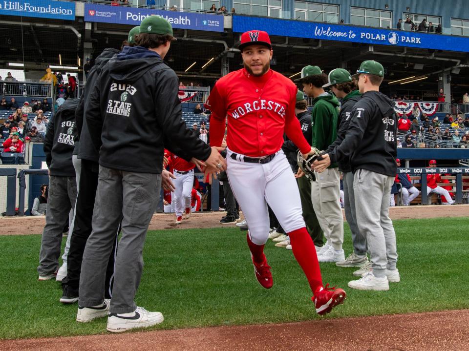 WooSox outfielder Corey Rosier takes the field slapping hands with the Oakmont Regional High School state champion baseball team on opening day at Polar Park Tuesday.