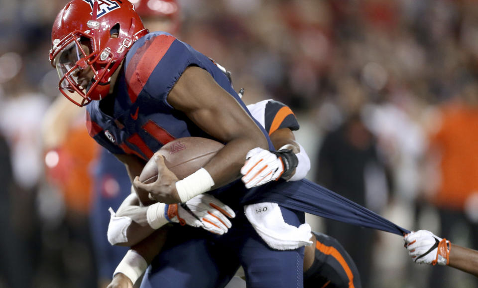 Arizona quarterback Khalil Tate (14) drags a couple of Oregon State defenders into the end zone on a touchdown run during the second quarter of an NCAA college football game Saturday, Nov. 11, 2017, Tucson, Ariz. (Kelly Presnell/Arizona Daily Star via AP)