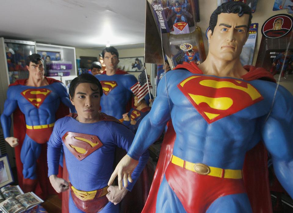 Herbert Chavez poses with his life-sized Superman statues inside his house in Calamba Laguna, south of Manila October 12, 2011. In his idolization of the superhero, Chavez, a self-professed "pageant trainer" who owns two costume stores, has undergone a series of cosmetic surgeries for his nose, cheeks, lips and chin down to his thighs and even his skin color to look more like the "Man of Steel". The final result bears little resemblance to his old self. REUTERS/Cheryl Ravelo (PHILIPPINES - Tags: SOCIETY)