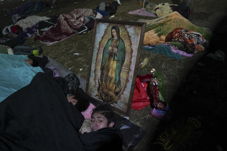 Pilgrims sleep outside the Basilica of Guadalupe on her feast day in Mexico City, early Tuesday, Dec. 12, 2023. Devotees of Our Lady of Guadalupe gather for one of the world's largest religious pilgrimages on the anniversary of one of several apparitions of the Virgin Mary witnessed by an Indigenous Mexican man named Juan Diego in 1531. (AP Photo/Marco Ugarte)