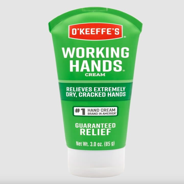 the green tube of hand cream on a grey background