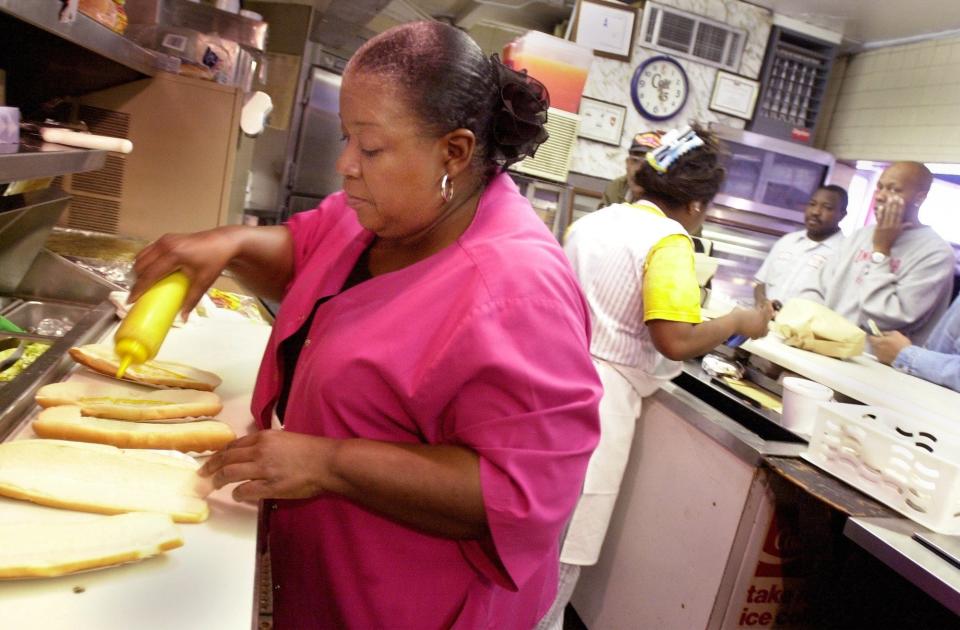 Rose Burgess prepares some footlong hot dogs Tuesday, March 12, 2002, at Vick's Drive-In. The footlong dogs were considered a specialty of Vick's, which was located off Murchison Road in Fayetteville, NC and closed in 2014.
