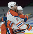 Edmonton Oilers' Adam Larsson (6) and Josh Archibald (15) celebrate a goal against the Vancouver Canucks during the third period of an NHL hockey game Tuesday, Feb. 23, 2021, in Vancouver, British Columbia. (Jonathan Hayward/The Canadian Press via AP)