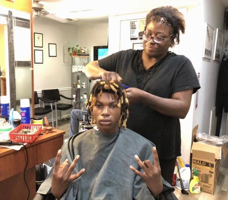 Cosmetology student Adia Buford twists Izaiah Terry's locs at Jazz Barber & Hairstyling Academy in Petersburg on Sept. 1, 2023.