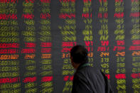 A man looks at an electronic board displaying stock prices at a brokerage house in Beijing, Thursday, Sept. 19, 2019. Shares were mixed in Asia on Thursday, with Tokyo and Sydney logging modest gains after the Federal Reserve cut its benchmark interest rate for a second time this year, citing slowing global economic growth and uncertainty over U.S. trade conflicts. (AP Photo/Andy Wong)