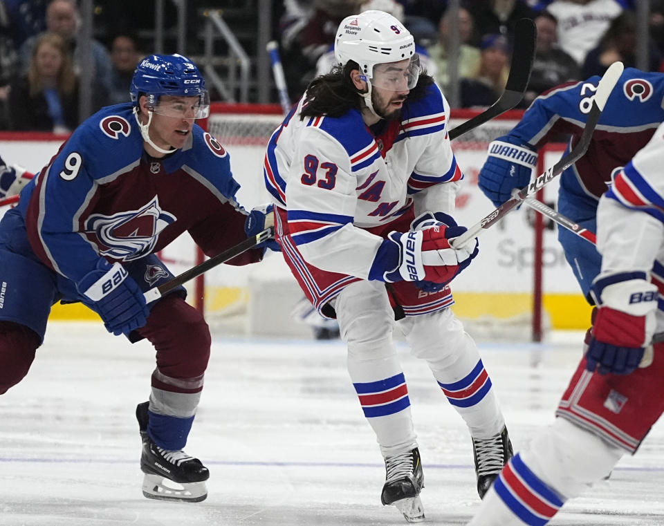 New York Rangers center Mika Zibanejad (93) passes the puck as Colorado Avalanche left wing Zach Parise defends during the second period of an NHL hockey game Thursday, March 28, 2024, in Denver. (AP Photo/David Zalubowski)