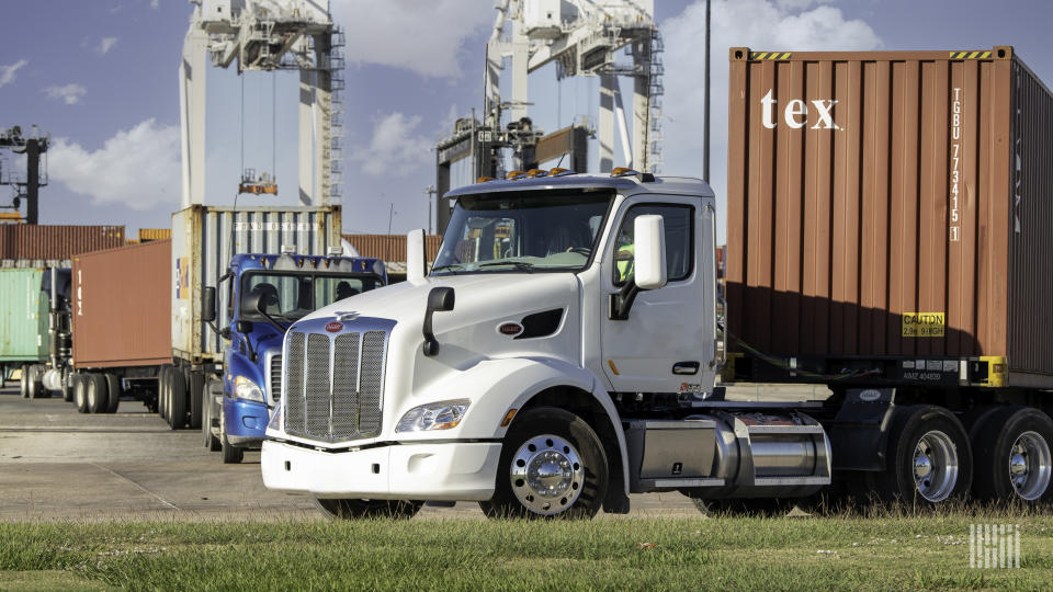 Trucks with containers leaving a port