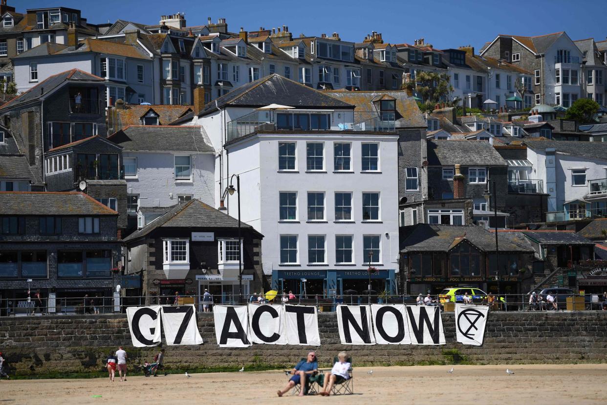 Extinction Rebellion environmental activists attach a banner calling on G7 leaders to act on climate change on the beach in St Ives, Cornwall during the G7 summit on June 13, 202 (AFP via Getty Images)