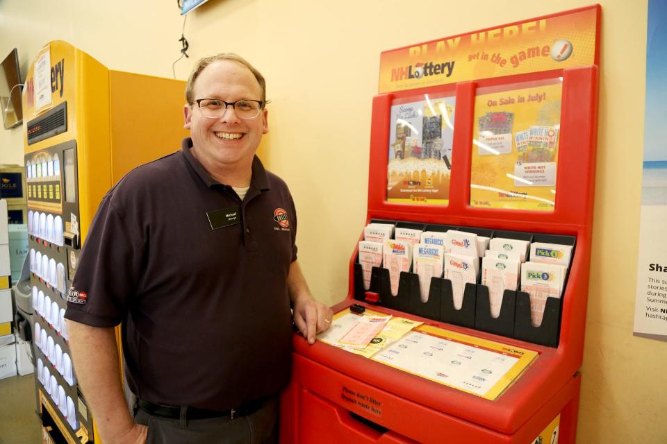 Michael Smith, manager at the New Hampshire Liquor & Wine Outlet on the Route 1 Bypass in Portsmouth, celebrates the $1 million Mega Millions lottery ticket sold at his store on Wednesday, July 20, 2022. The drawing was a day earlier.