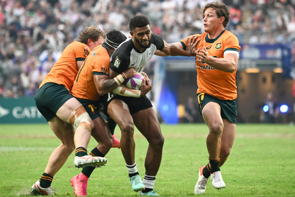 Fiji's Ponipate Loganimasi (C) fends off Australia's Michael Hooper (R) in their Pool A match at the 2024 Rugby Sevens Hong Kong tournament at the Hong Kong stadium on April 5, 2024. (Photo by Peter PARKS / AFP) (Photo by PETER PARKS/AFP via Getty Images)