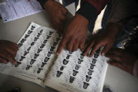 Indigenous Tzotzil people checks their names on a list during a non-binding national referendum on whether Mexican ex-presidents should be tried for any illegal acts during their time in office, at the Corazon de Maria community, in Chiapas state, Mexico, Sunday, August 1, 2021. (AP Photo/Emilio Espejel)