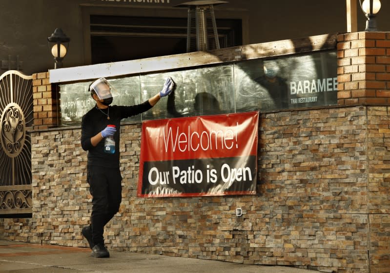 San Pedro, California-Jan. 29, 2021- At Baramee Thai Restaurant in San Pedro, California, an employee washes the windows as they reopen for outdoor dining on Jan. 29, 2021. (Carolyn Cole / Los Angeles Times)