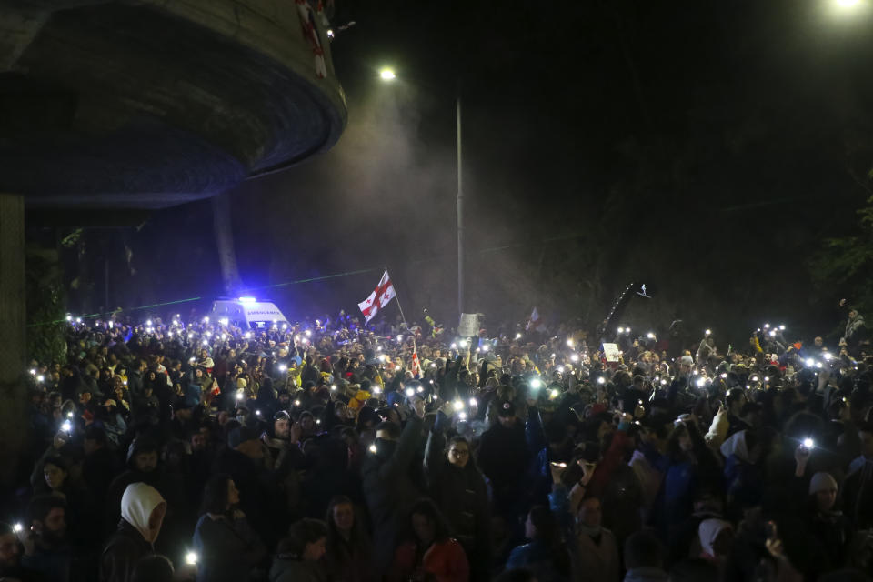Demonstrators hold up their smart phones with the torch lights switched on as they gather in the Square of Heroes during an opposition protest against "the Russian law" in the center of Tbilisi, Georgia, Tuesday, May 14, 2024. The Georgian parliament on Tuesday approved in the third and final reading a divisive bill that sparked weeks of mass protests, with critics seeing it as a threat to democratic freedoms and the country's aspirations to join the European Union. (AP Photo/Zurab Tsertsvadze)
