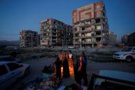 Quake survivors huddle by a fire as temperatures drop in Sar-e Pol-e Zahab in western Iran