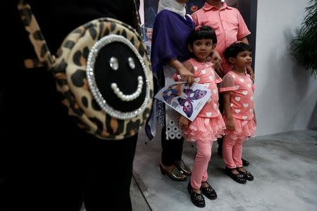 Sanzida (L), 6, looks on beside her younger sister Shahzia, 5, as they and their parents attend an awareness arts show on refugees in Hong Kong June 16, 2016, after the family fled Bangladesh. REUTERS/Bobby Yip