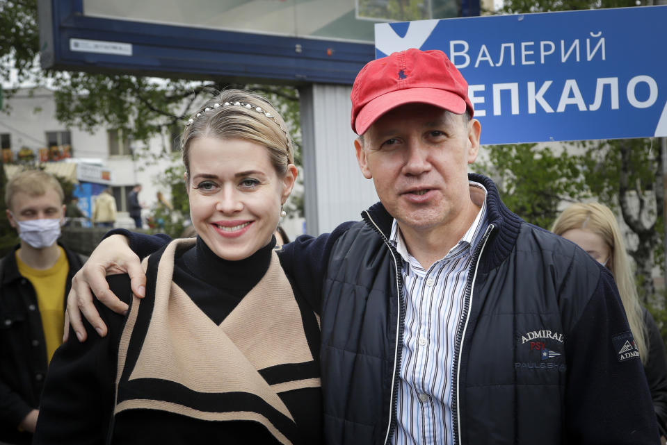 In this photo taken on Tuesday, May 26, 2020, Valery Tsepkalo, a former ambassador to the United States and founder of a successful hi-tech park, hugs his wife Veronika, as he speaks to the media in Minsk, Belarus. Valery Tsepkalo who fled to Russia after being denied a ballot spot in next month’s presidential election says he my not be able to return home if authoritarian President Alexander Lukashenko wins another term. He fled to Russia last week and said he had received tips that his arrest was imminent. (AP Photo/Sergei Grits)