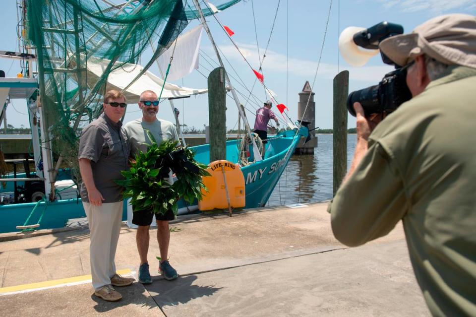 Mississippi Gov. Tate Reeves poses for a photo with a wreath that is dropped into the ocean during the Blessing of the Fleet at the Point Cadet Marina on Sunday, May 28, 2023.