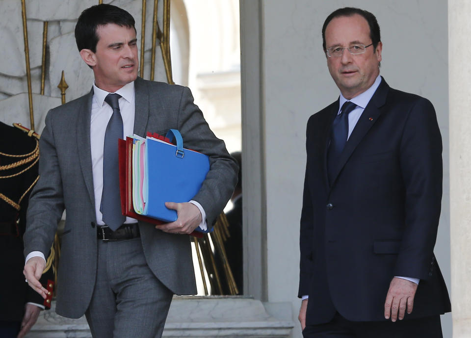 French Prime Minister Manuel Valls, left, and French president Francois Hollande leave at the end of the Cabinet meeting at the Elysee Palace in Paris Wednesday, April . 23, 2014. (AP Photo/Jacques Brinon)