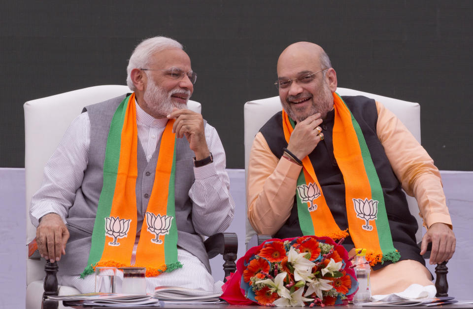 FILE - In this April 8, 2019, file photo, Indian Prime Minister Narendra Modi, left, and Bharatiya Janata Party (BJP) President Amit Shah attends the release of BJP's manifesto for the upcoming general elections in New Delhi, India. Modi’s vision of a Hindu India took a leap forward with his government’s decision in August to subsume Kashmir into the federal government by eliminating its special status and allowing anyone to buy property and move into the state, raising fears among residents that they will lose their distinct identity. Modi’s home minister, Amit Shah, considered the architect of the Hindu nationalist-led government’s aggressive agenda to convert India from a secular, multicultural democracy into a distinctly Hindu, culturally and politically homogenous state, sold the new policy on Kashmir to parliament by equating it with Pakistan, India’s staunch foe. (AP Photo/Manish Swarup, File)