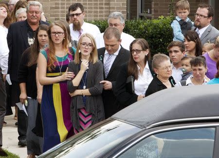 Cassidy Stay, 15, is comforted by family members after the funeral service for members of the Stay family at the Church of Jesus Christ of Latter-Day Saints in Spring, Texas July 16, 2014. REUTERS/Daniel Kramer