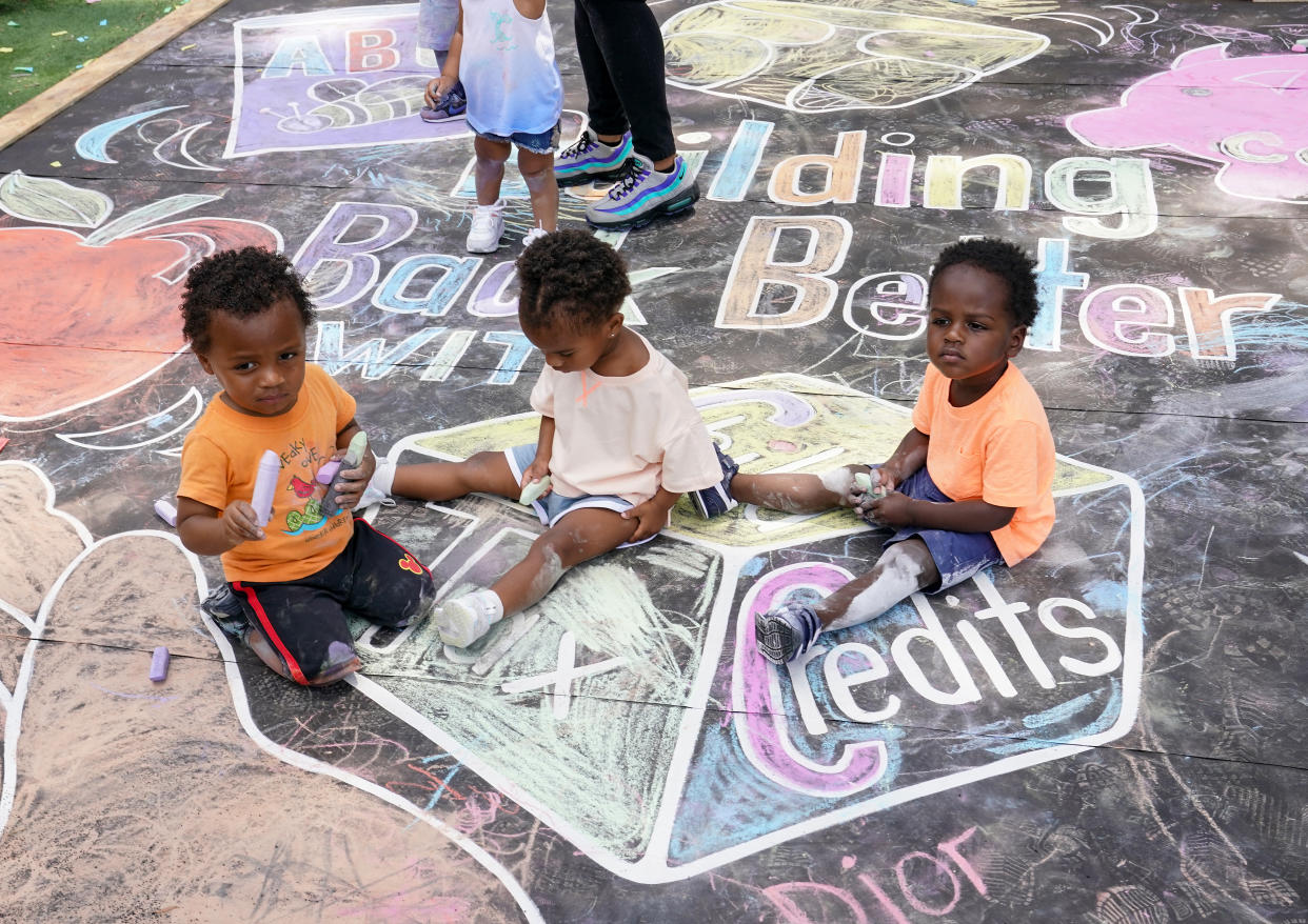 Children and teachers from the KU Kids Deanwood Childcare Center complete a mural in celebration of the launch of the Child Tax Credit on July 14, 2021 at the KU Kids Deanwood Childcare Center in Washington, DC. (Photo by Jemal Countess/Getty Images for Community Change)