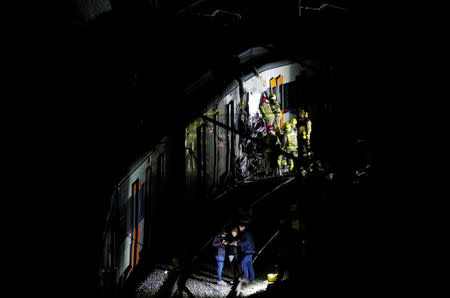 Rescue personnel inspect the site of a train crash near Manresa, Spain, February 8, 2019. REUTERS/Albert Gea