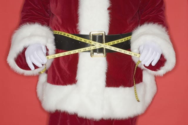 Santa Claus measuring waist with tape measure