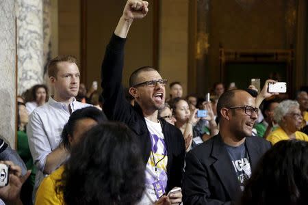 A man celebrates after the Los Angeles City Council approved a proposal to increase the minimum wage to $15.00 per hour in Los Angeles, California June 3, 2015. REUTERS/Jonathan Alcorn