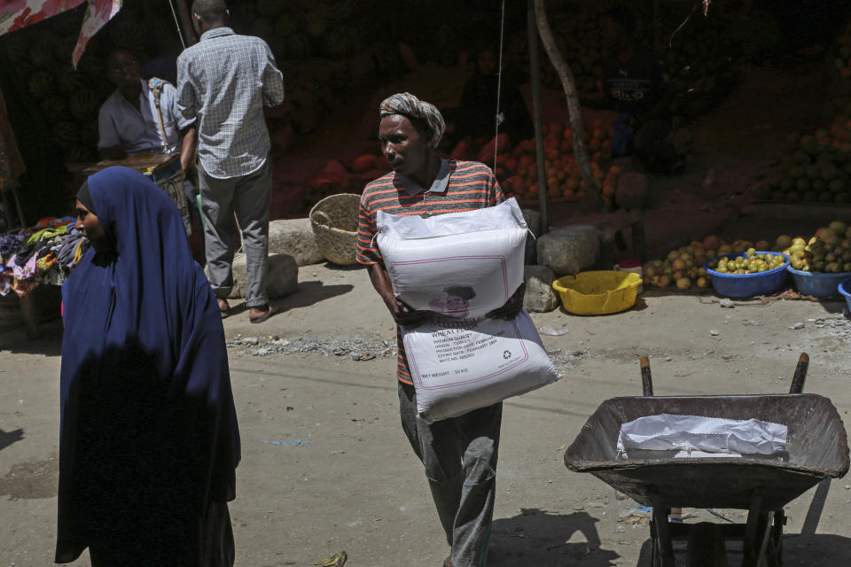 FILE - A man carries a sack of wheat flour imported from Turkey in the Hamar-Weyne market in the capital Mogadishu, Somalia Thursday, May 26, 2022. Bill Gates urged world leaders not to give up on the goals they set to reduce hunger and poverty despite huge recent setbacks documented in a new report released Tuesday, Sept. 13 by The Bill and Melinda Gates Foundation. (AP Photo/Farah Abdi Warsameh, File)