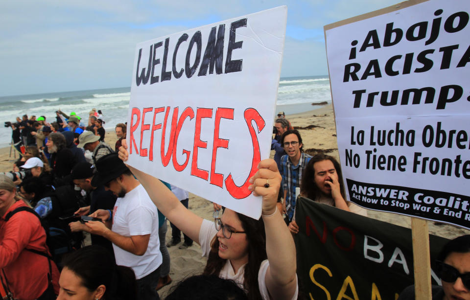 Pro-migrant caravan demonstrators rally at the west end of the U.S.-Mexico border.