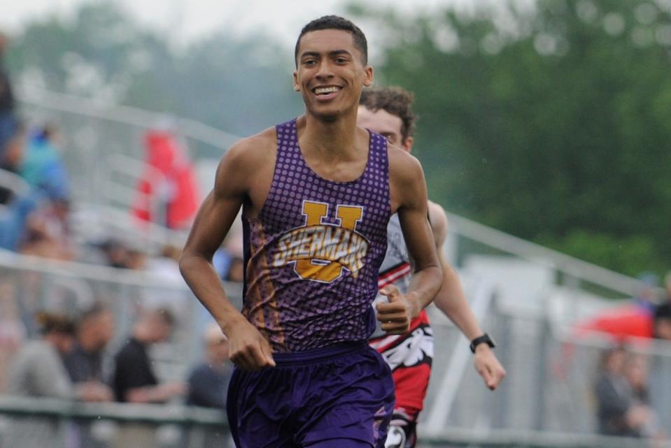 Unioto's Ashton Beverly flashes a smile as he leads the pack during the boys 800m run in the Scioto Valley Conference track and field championships at Huntington High School on May 12, 2023.