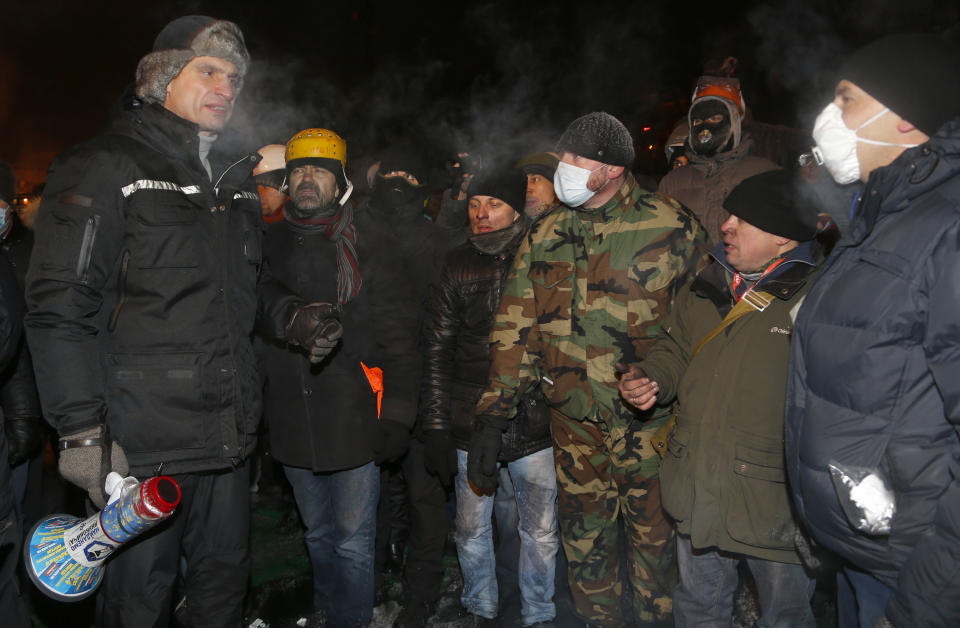 Opposition leader and former WBC heavyweight boxing champion Vitali Klitschko, left, addresses protesters near the barricades between police and protesters in central Kiev, Ukraine, early Friday Jan. 24, 2014. Emerging from hours-long talks with President Viktor Yanukovych, opposition leader Oleh Tyahnybok asked demonstrators in Kiev for several more days of a truce, saying the president has agreed to ensure the release of dozens of detained protesters and stop further detentions. (AP Photo/Sergei Grits)