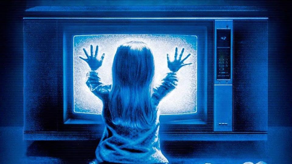 carol anne puts both hands on a staticky tv in a scene from 'poltergeist,' a good housekeeping pick for best halloween movies