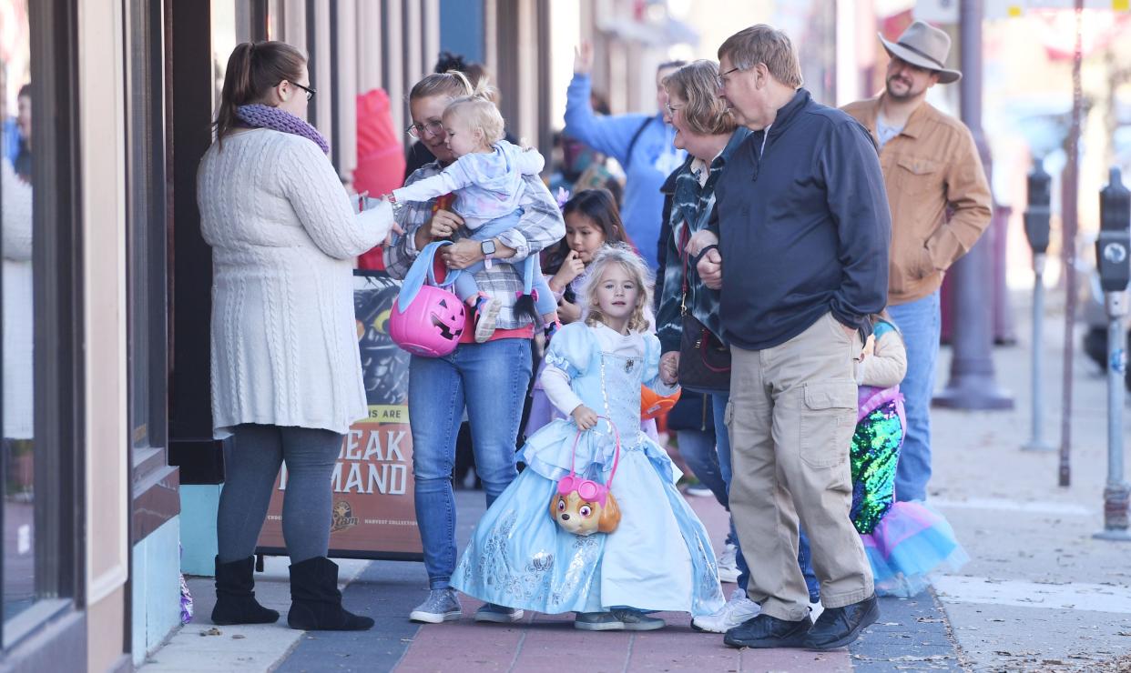 Children walk around with their parents on Main Street with Halloween costumes to collect candies at the downtown Trick or Treating event Friday, Oct. 28, 20022, in Ames, Iowa.