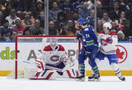 The puck hits the post and stays out of the net behind Montreal Canadiens goalie Sam Montembeault, left, as Vancouver Canucks' Pius Suter (24) and Montreal's Rafael Harvey-Pinard (49) watch during the first period of an NHL hockey game Thursday, March 21, 2024, in Vancouver, British Columbia. (Darryl Dyck/The Canadian Press via AP)