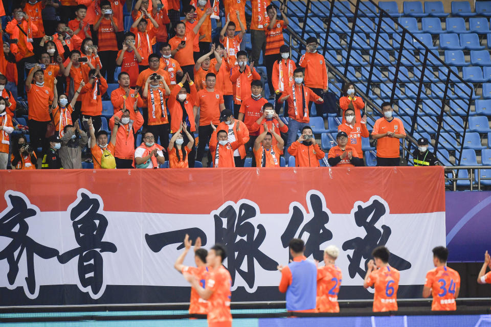 Foto del 17 de octubre del 2020 aficionados del Shandong Luneng aplauden a su equipo durante el encuentro ante el Beijing Guoan en Suzhou en la Super Liga. El martes 24 de mayo del 2022, el Chongqing Liangjiang se dio de baja de la Super Liga de China debido a que no ha podido pagarle a jugadores. (Xu Chang/Xinhua vía AP, Archivo)
