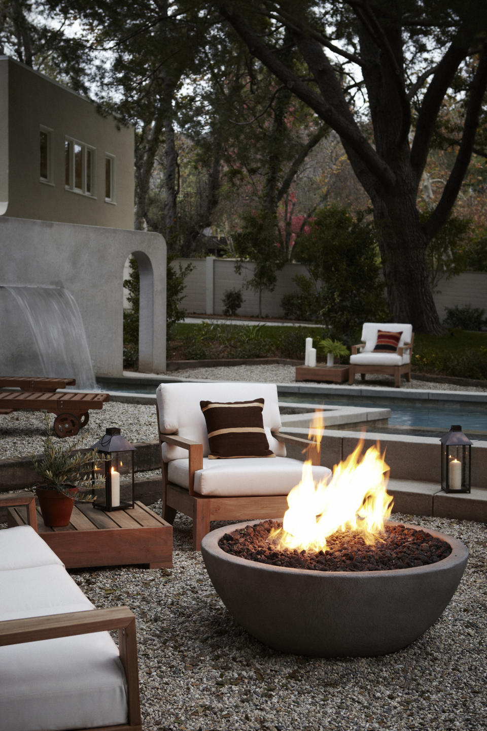 <p> Warm up your courtyard with this big ol&apos; fire pit idea which adds warmth and coziness to what is quite an open space. Setting this on gravel creates a cool contrast to the fire pit&apos;s smooth exterior but nods to the textured interior also for an all-around streamlined, stylish look. </p>