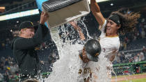 Pittsburgh Pirates' Ke'Bryan Hayes, bottom, has a chest of ice and water dumped onto him in celebration by Cole Tucker, right, and Mitch Keller, left, after Hayes drove in the winning run in the team's baseball game against the Washington Nationals, Friday, Sept. 10, 2021, in Pittsburgh. The Pirates won 4-3. (AP Photo/Keith Srakocic)