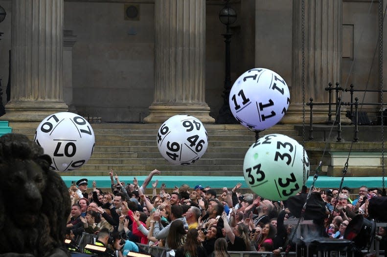 A series of inflatable lottery balls being tossed around in a crowd in Liverpool, England on May 7, 2023