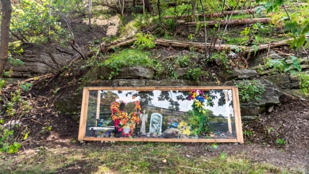 Timothy Johnstone and fellow construction workers put together a Plexiglas box to protect a memorial they discovered on their job site behind Parliament Hill.  (Alexander Behne/CBC - image credit)