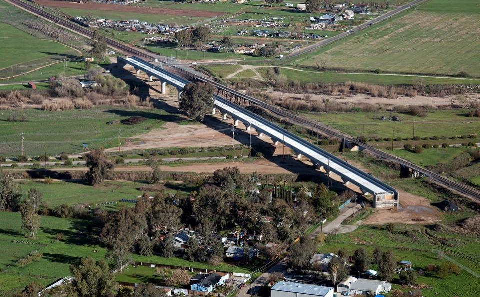 Aerial view of a viaduct being built next to a rural highway