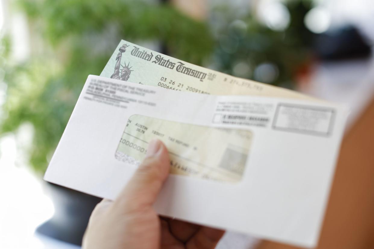 Man receives a tax refund check from the government; Indoor background