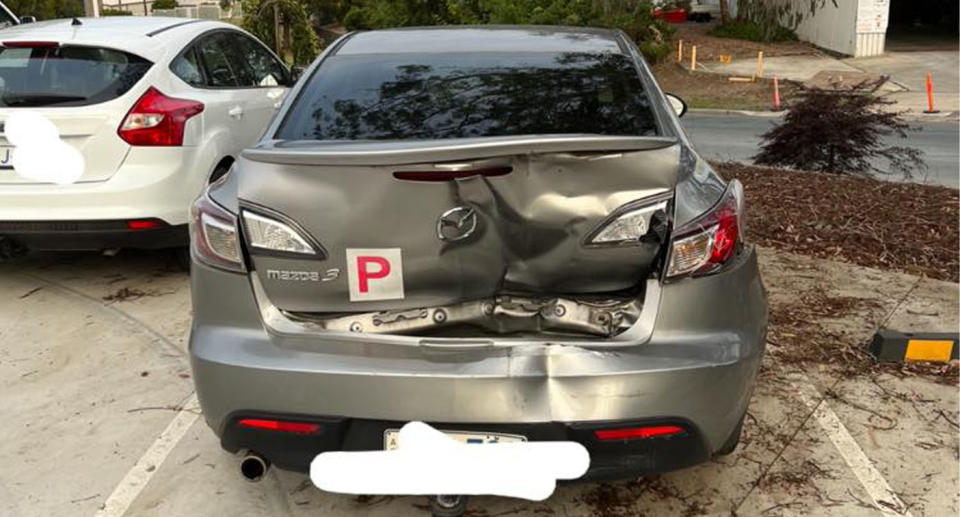 Smashed Mazda 3 with red P-plate driver.