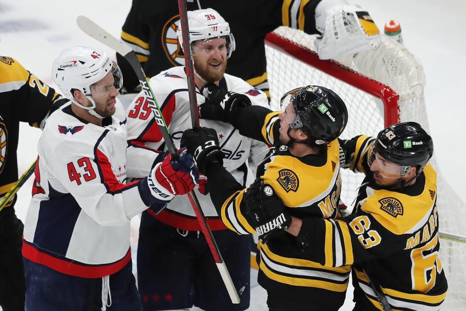 Washington Capitals' Tom Wilson (43) and Anthony Mantha (39) scuffle with Boston Bruins' Charlie McAvoy (73) and Brad Marchand (63) during the second period in Game 4 of an NHL hockey Stanley Cup first-round playoff series, Friday, May 21, 2021, in Boston. (AP Photo/Michael Dwyer)